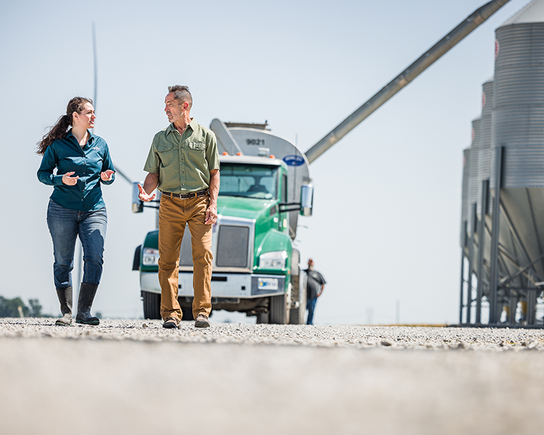 Swine producer and Purina consultant walking on farm